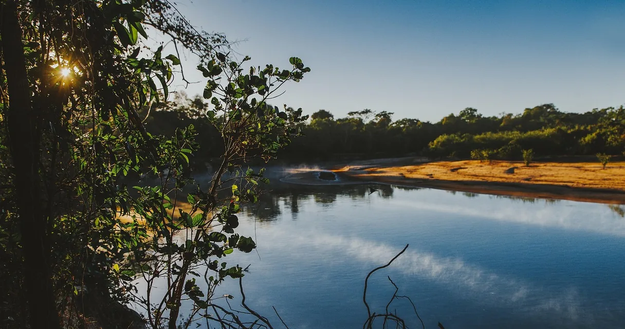 Rio de águas calmas cercado por vegetação nativa em área rural de Goiás